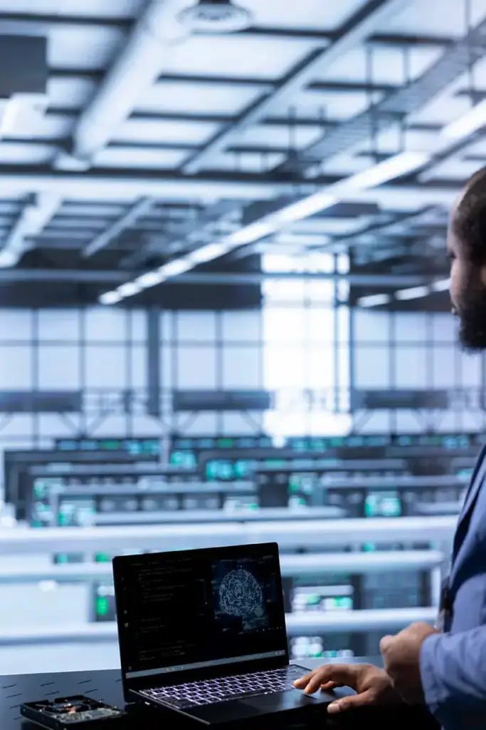 Mann steht vor Laptop mit digitaler Grafik.